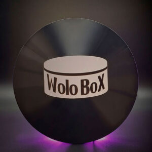 una wolobox en primer plano sobre un fondo oscuro y una luz morada que proviene de detras de la consola dandole un aspecto cyberpunk