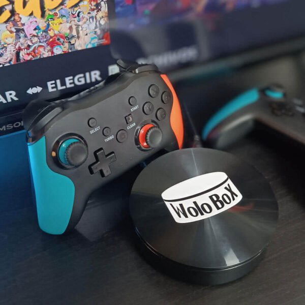 una wolobox y dos gamepads pro sobre una mesa de color negro